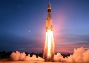 PSLV-C60 rocket lifting off, fiery exhaust against a twilight sky